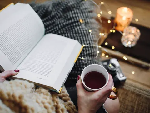 Açık bir kitap ve sıcak bir fincan çay